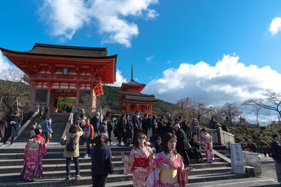 Group of people outside temple against buildings