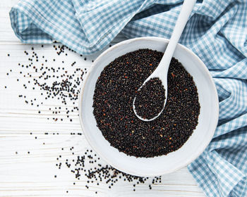 Black quinoa seeds on a old wooden background