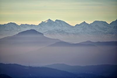 Scenic view of snowcapped mountains against sky during sunset