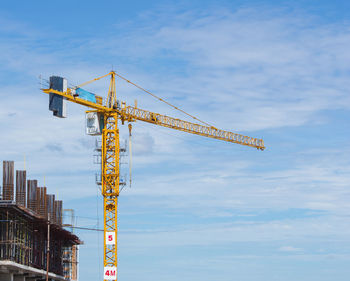 Low angle view of crane against sky