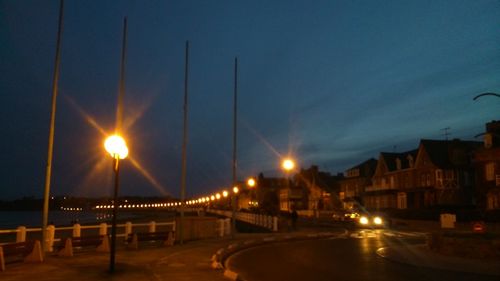 Illuminated bridge against sky at night