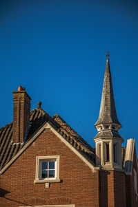 Brick building facade and roofs at sunset in the city center of tielt. charming village in belgium.