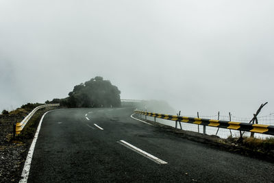 Empty road against sky during foggy weather