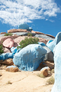 Painted rocks at beach against sky