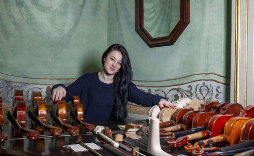 Fascinating violinist showing his collection of handcrafted violins at home