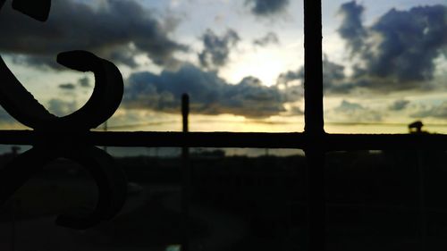 Close-up of silhouette metal against sky during sunset