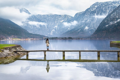 Scenic view of lake by snowcapped mountains against sky