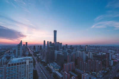 Aerial view of buildings in city against sky during sunset