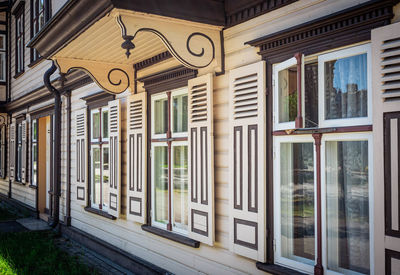 A cream-colored house with brown windows and beautiful architecture in the center of town