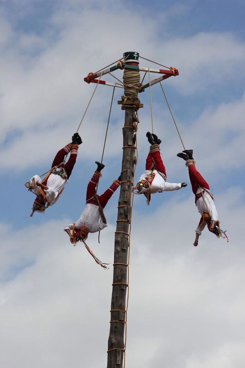 LOW ANGLE VIEW OF PEOPLE POLE AGAINST SKY