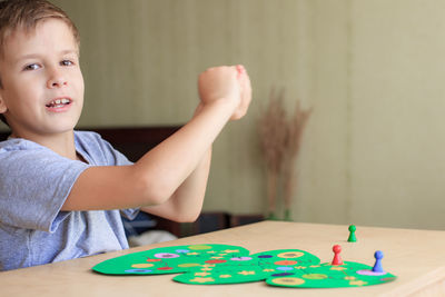 Child rolls the dice and moves the chip across the christmas playing field. 