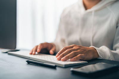 Midsection of man using laptop at office