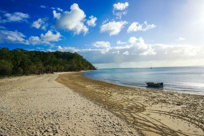 View of calm beach against blue sky