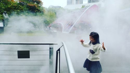 Girl standing against fountain in park