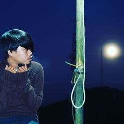 Close-up of boy holding illuminated lighting equipment at night