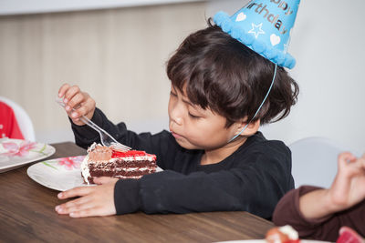 Close-up of boy eating birthday cake