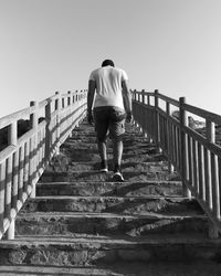 Full length rear view of man walking on steps