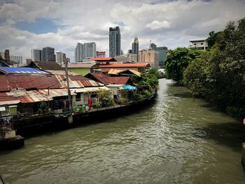 River amidst buildings in city against sky