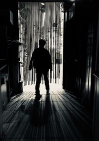 Rear view of silhouette man walking in corridor