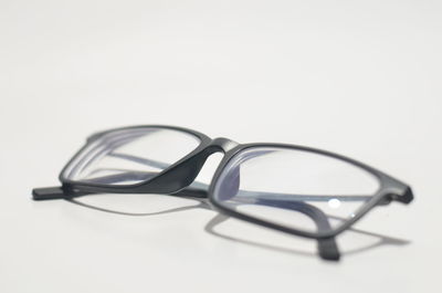 Close-up of eyeglasses on table against white background