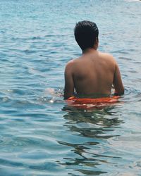 Rear view of shirtless man in swimming pool