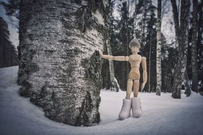 Full length of boy climbing on tree in forest