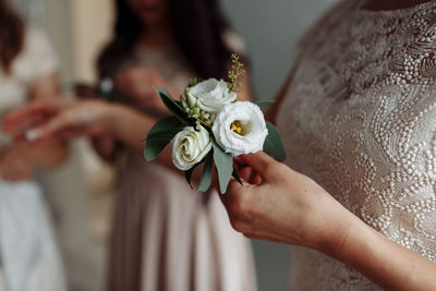 Midsection of bride holding bouquet