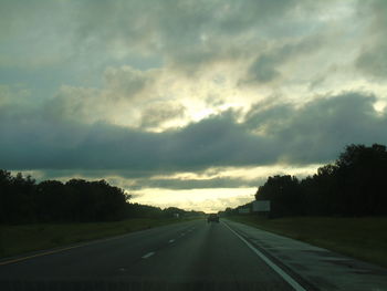 Empty road against cloudy sky