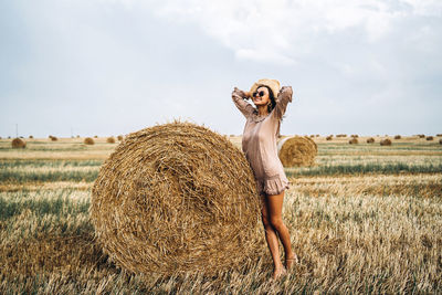 Full length of woman standing on field against sky