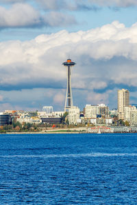 Architecture of the seattle skyline with elliott bay in front and clouds above.