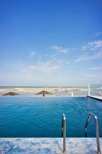 Scenic view of swimming pool by sea against sky