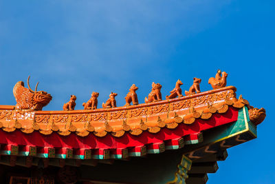 Cropped image of shrine against blue sky