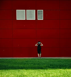 Full length of man standing on field against building