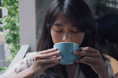 Close-up of young woman drinking coffee