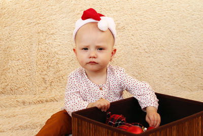 Portrait of cute girl sitting on sofa at home