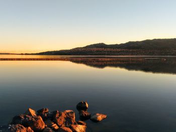 Beautiful tranquil  lake scene with water reflections at sunset