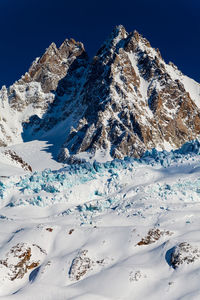 Scenic view of snowcapped mountain against clear blue sky