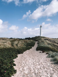 Lighthouse by sea against sky