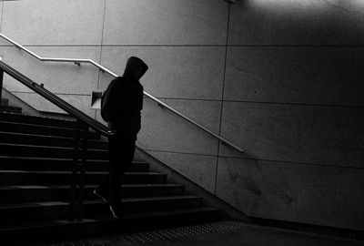 Rear view of silhouette person walking on staircase