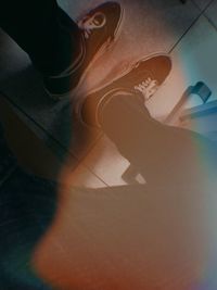 Low section of woman sitting on hardwood floor