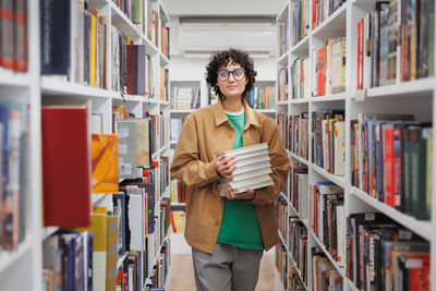 Young woman using mobile phone in library