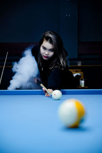 Young woman playing pool