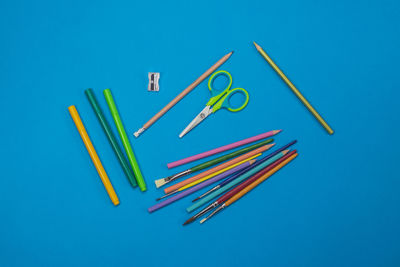 High angle view of colored pencils against blue background