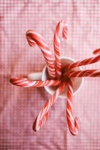 Directly above shot of candy canes in cup on table