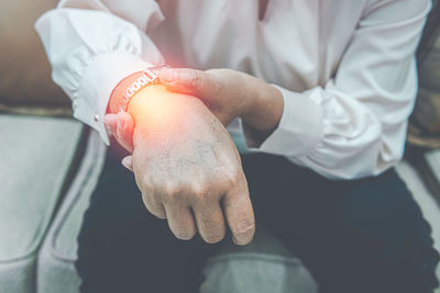 Close up older woman suffering from wrist pain, health problem and people concept