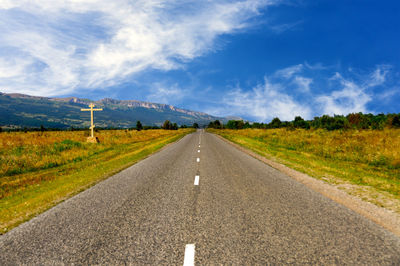 Road passing through landscape against sky