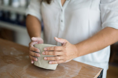 Midsection of person preparing food on table