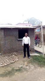 Full length of man standing against building