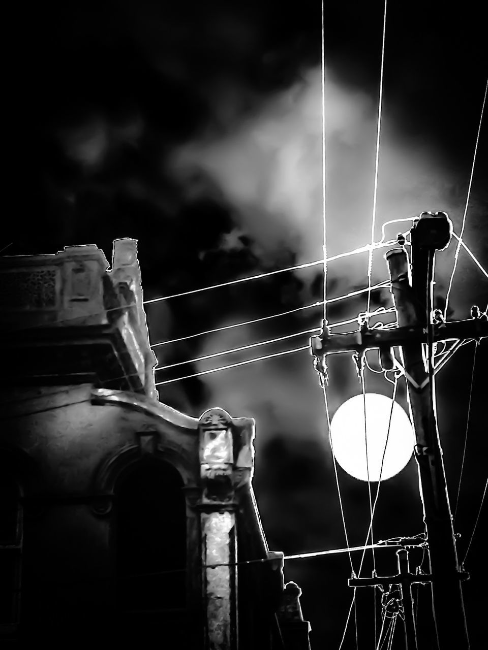 low angle view, sky, arts culture and entertainment, amusement park, night, illuminated, amusement park ride, outdoors, built structure, cloud - sky, connection, electricity, technology, lighting equipment, dusk, silhouette, focus on foreground, no people, architecture, metal