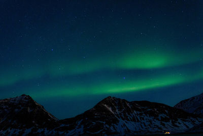 Scenic view of snowcapped mountains against sky at night